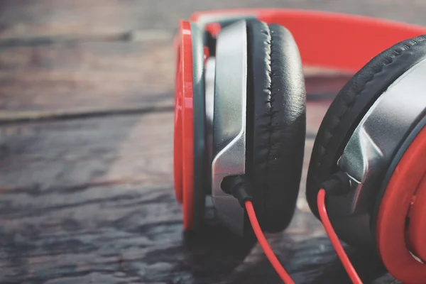 Red headphones on wood background