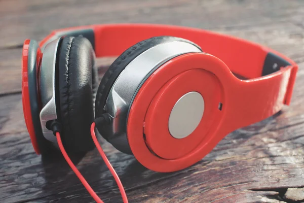 Red headphones on wood background