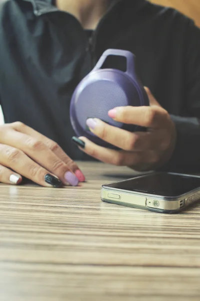 Woman using bluetooth speaker with smart phone