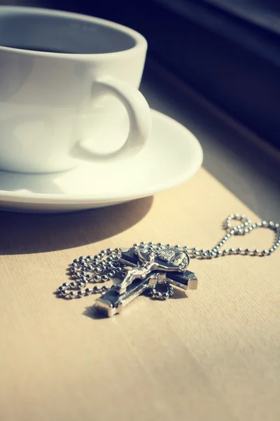 Hot coffee and necklace with cross