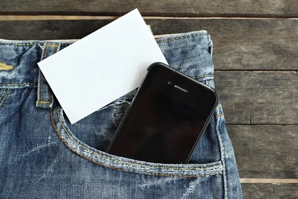 Smart phone with blank card on jeans