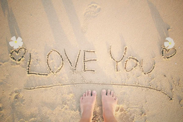 Selfie of word love you written in sand on beach