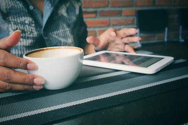 Woman drinking coffee cup with tablet in coffee shop