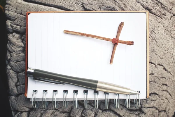 Blank notepad and pen with cross