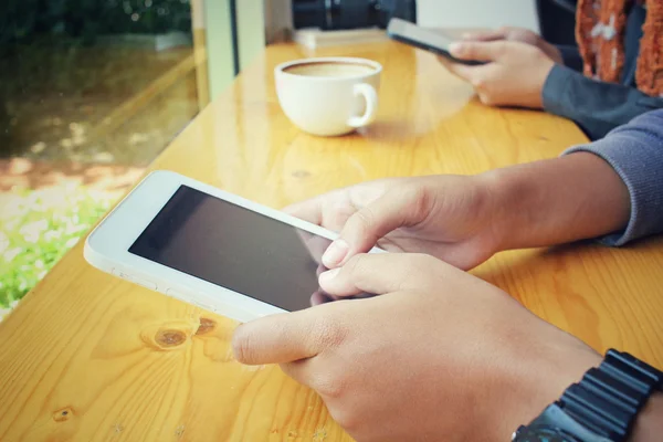 Male and female couple with tablet sitting indoor in trendy urban cafe.