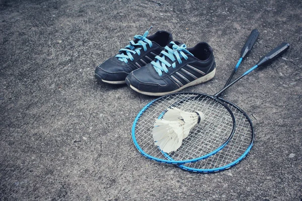 Sport shoes with shuttlecocks and badminton racket.