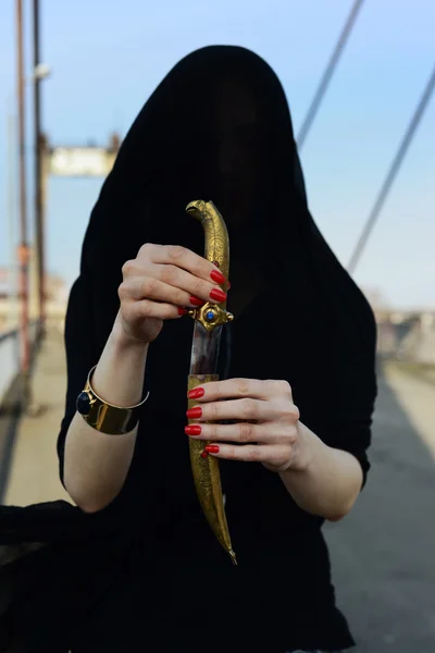 Girl in black with an oriental dagger