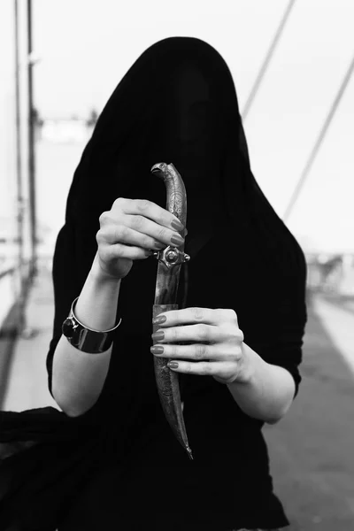 Girl in black with an oriental dagger