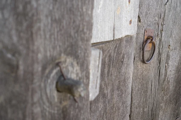Old run-down wooden door and wooden lock out of focus