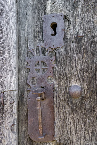 Old run-down wooden door and decorated iron lock