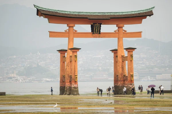 Miyajima, Floating Torii gate in Japan with blurred tourists.