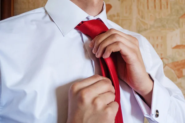 Man Fixing his Tie