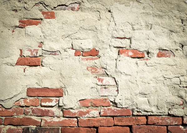 Old brick wall with fallen plaster