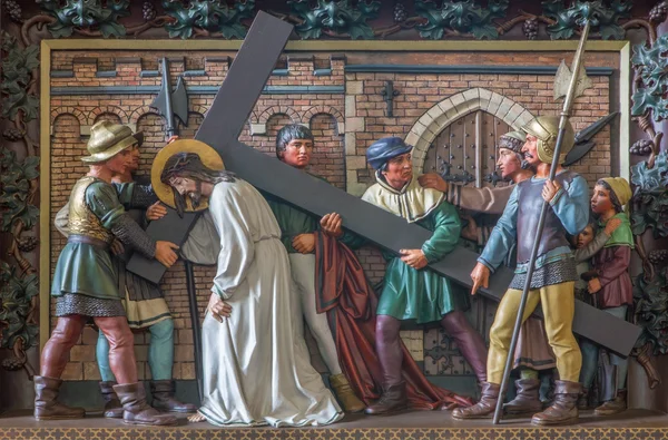 BRUGES, BELGIUM - JUNE 13, 2014:  Simon of Cyrene help Jesus to carry his cross. Relief in st. Giles church (Sint Gilliskerk) as part of the Passion of Christ cycle.