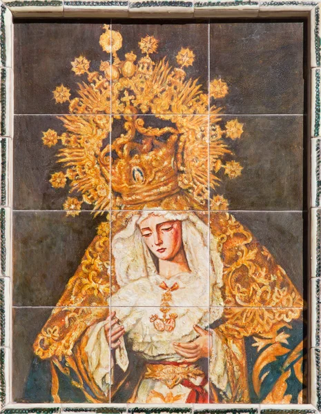 SEVILLE, SPAIN - OCTOBER 27, 2014: The ceramic tiled cried Madonna (Lady of Sorrow) with the cross by artist Enrique Orce Marmol on the church Iglesia San Roque.