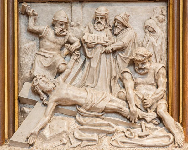 VIENNA, AUSTRIA - DECEMBER 17, 2014: The Jesus is nailed to the cross relief as one part of Cross way cycle in Sacre Coeur church by R. Haas from end of 19. cent.