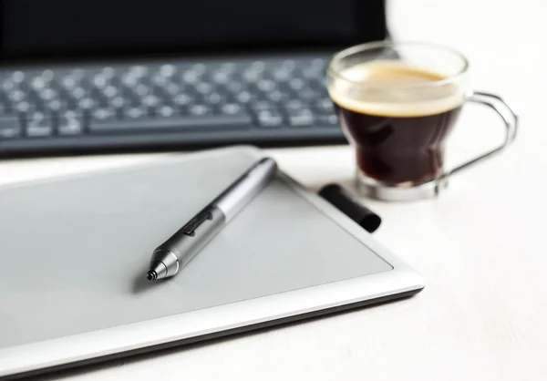 Digital tablet, stylus pen, tablet pad and cup of coffee.