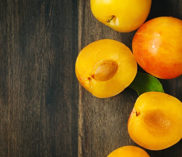 Yellow plums on wooden background with copy space. Stone fruits