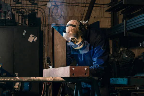 An industrial welder welding iron in workplace