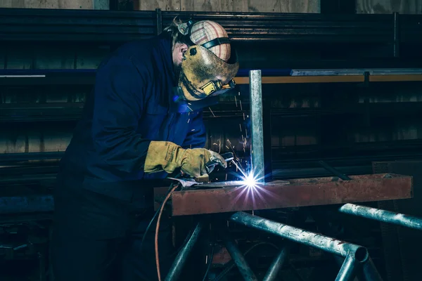 Welder welding iron in workplace