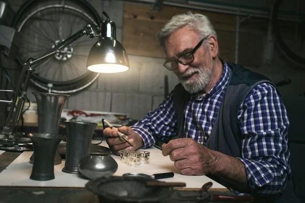 Man soldering metal rings