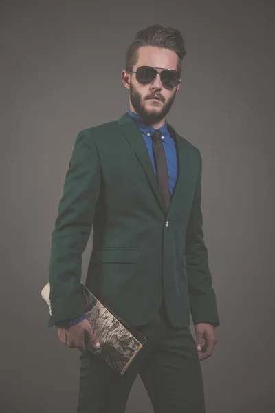 Business fashion man wearing green suit with sunglasses and blue