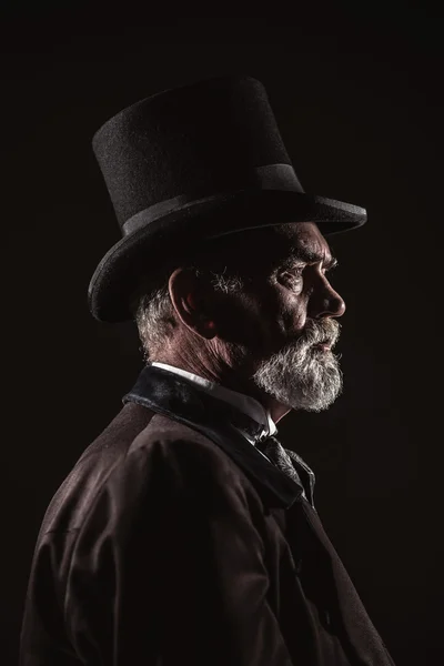 Vintage victorian man with black hat and gray hair and beard. St