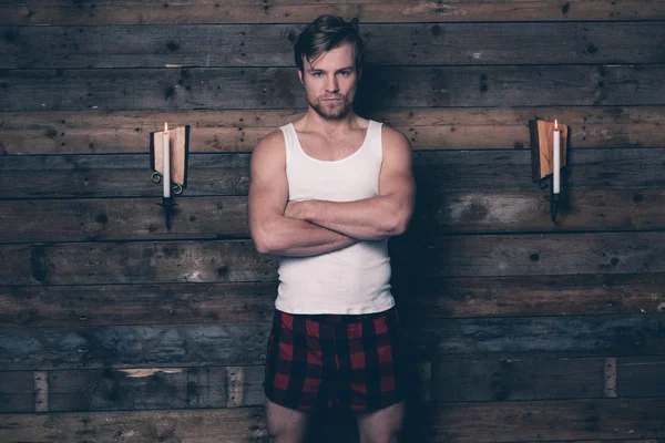Man with blonde hair wearing white singlet shirt and red flannel