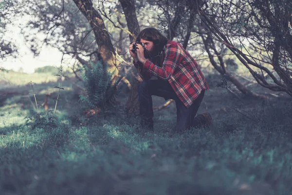 Nature photographer kneeling down to take a shot