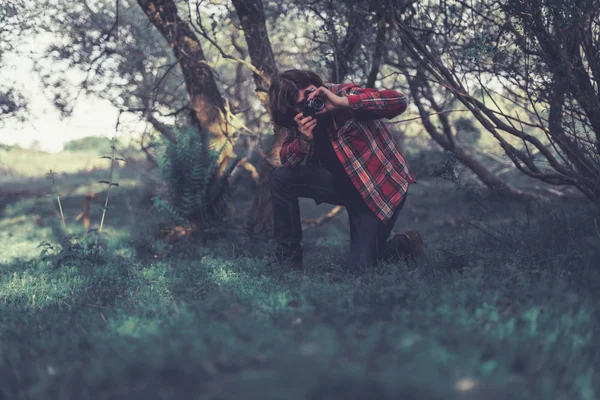 Nature photographer kneeling down to take a shot