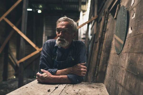 Lonely farmer inside wooden barn