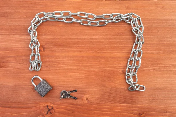 Metal chain links and lock on wooden background