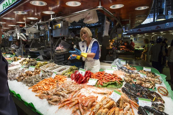 BARCELONA, SPAIN - JUNE 23, 2015: People buying food inside Mercat de Sant Josep de la Boqueria. It is a large public market in the Ciutat Vella district of Barcelona.