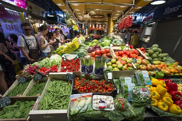 BARCELONA, SPAIN - JUNE 23, 2015: People buying food inside Mercat de Sant Josep de la Boqueria. It is a large public market in the Ciutat Vella district of Barcelona.