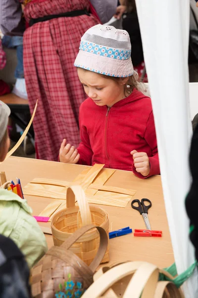 Master class teaching children folk crafts weaving a basket