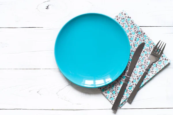 Empty blue plate at wooden table