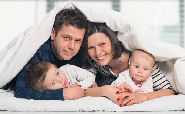 Happy family with children in bed