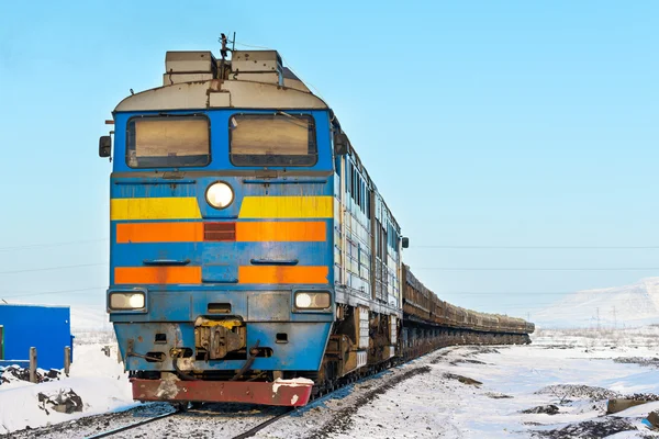 Freight train moving on snow-covered tracks.