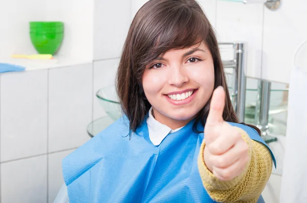 Attractive young woman thumb up in dentistry office