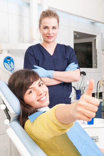 Doctor and patient giving thump up at dentist office