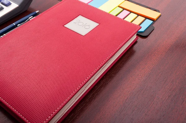 Close-up of notebook planner and sticky notes as pov
