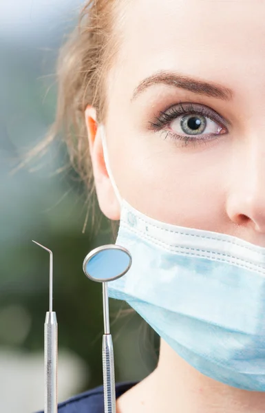Close-up of half woman dentist face wearing mask