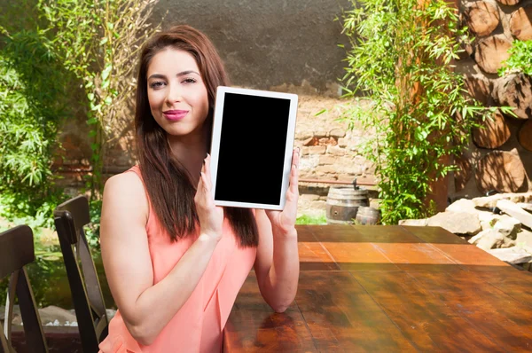 Lady holding tablet with black screen on terrace