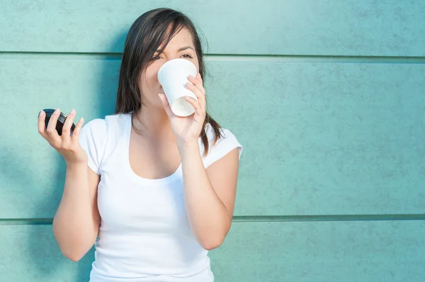 Young pretty girl drinking from takeaway coffee mug