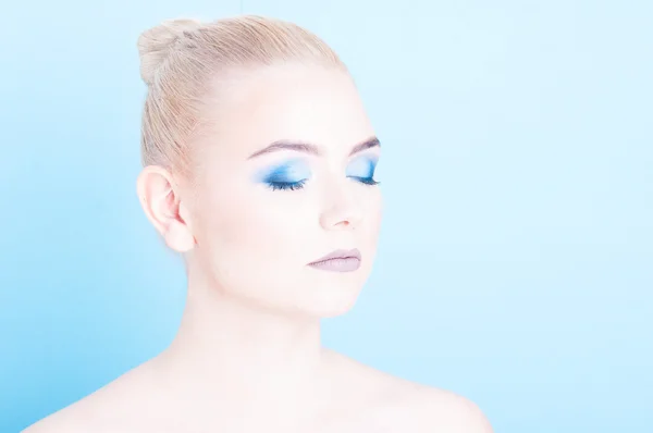 Girl posing with eyes closed and blue eye make-up