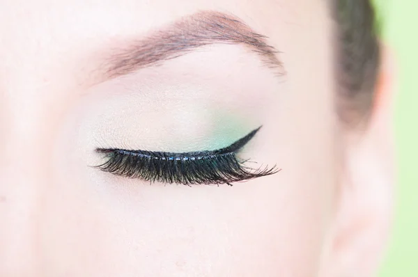 Close-up of professional green eye make-up