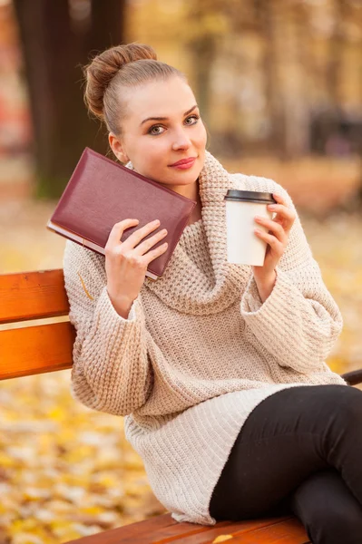 Beautiful female holding book and coffee
