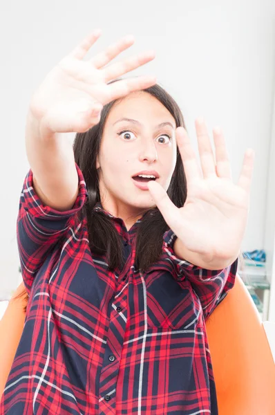 Lady sitting in dentist chair making don\'t touch me gesture