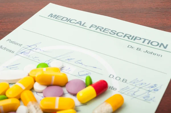 Closeup of a medical prescription with pills on top
