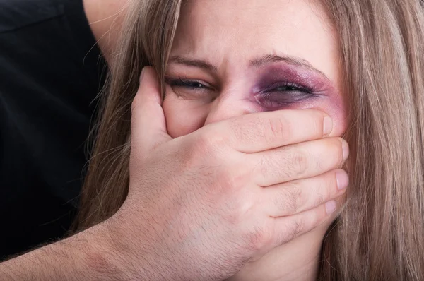 Aggressive man grabbing beaten woman mouth
